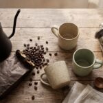 Best gifts for coffee lovers — pour-over kettle, coffee beans, mug and French press on a wooden table