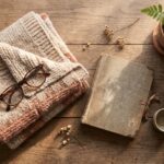 best gifts for grandparents flat lay with a knitted blanket, reading glasses, photo album, tea set and potted plant